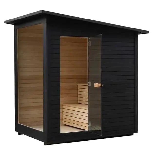 The Lunara Cabin Sauna - 4 person is a modern black outdoor sauna with a slanted roof, large glass door and window. Inside, premium solid wood benches and paneling offer comfort and style, visible through the sauna’s transparent sections.