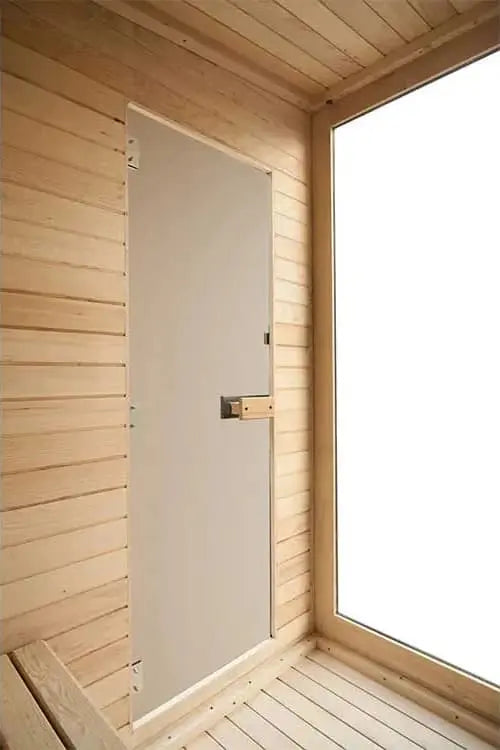 The Lunara Cabin Sauna - 4 person features a minimalist solid wood interior, a closed door with a simple latch, and a large frosted window that lets in diffused light—ideal for relaxing with powerful heating.
