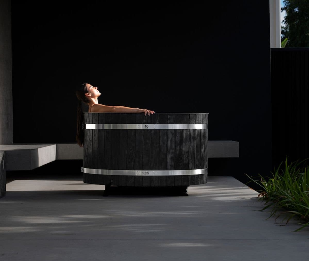 Woman enjoying a luxury cold plunge in a modern spa-inspired outdoor setting – Lunara Collective